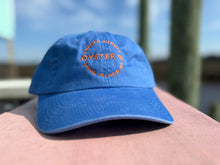 Load image into Gallery viewer, Blue cap with 'French Hermit Oyster Co; Deer Island, MS' branding on a blurred background